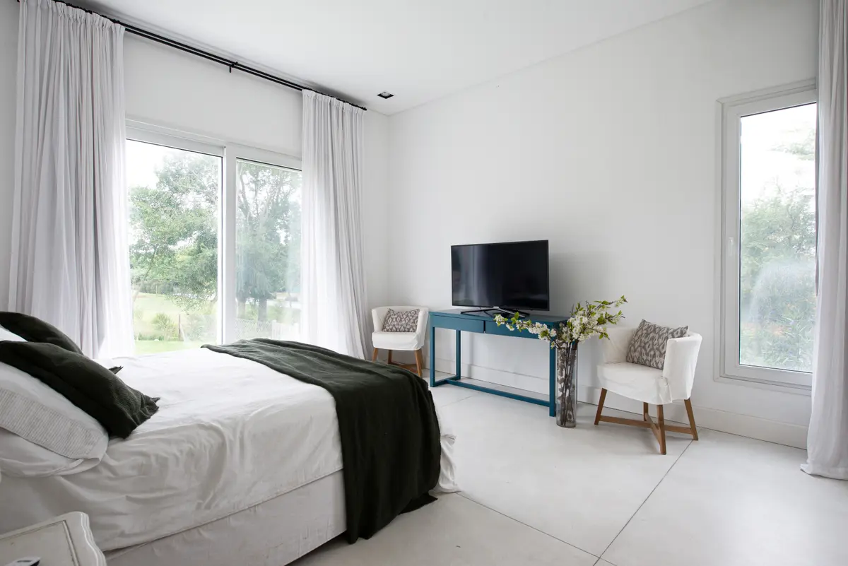 Dormitorio moderno minimalista con vista al campo y mucha luz — proyecto San Matias, por Parq Estudio, en Buenos Aires